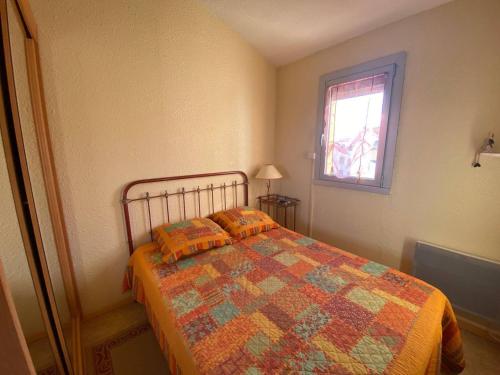 - une chambre avec un lit doté d'une couette et d'une fenêtre dans l'établissement Appartement T2+Mezzanine, 6 pers, Clim, Parking, 400m des commerces - FR-1-81-562, à Port-Leucate