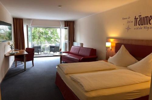 a hotel room with a bed and a chair at Hotel Häfner in Bad Schonborn