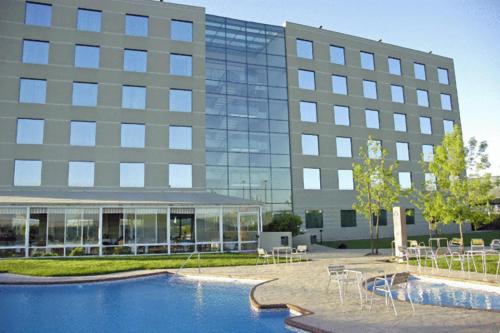 ein Gebäude mit einem Pool vor einem Gebäude in der Unterkunft Hotel Diego de Almagro Aeropuerto in Santiago