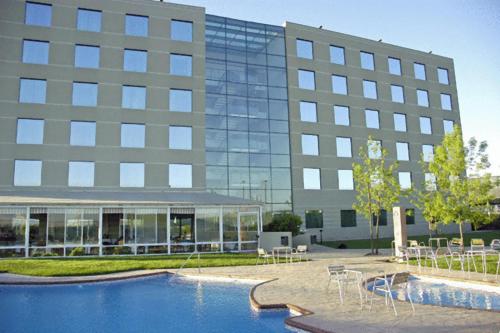 un edificio con piscina frente a un edificio en Hotel Diego de Almagro Aeropuerto, en Santiago