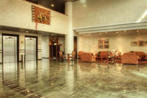 un hall avec des canapés et des tables dans un bâtiment dans l'établissement Hotel Diego de Almagro Aeropuerto, à Santiago