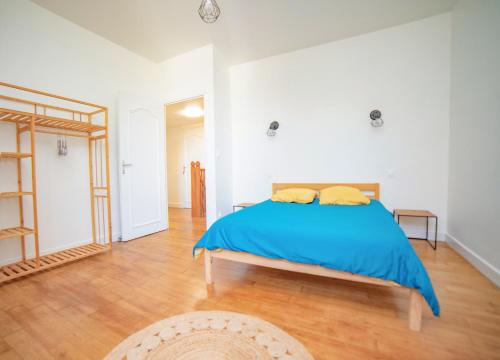 1 dormitorio con 1 cama con manta azul en Le petit cocon de la butte, en Gourdon-en-quercy
