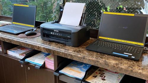 two laptop computers and a printer on a counter at Toyoko Inn Osaka Nippombashi Bunraku Gekijo Mae in Osaka