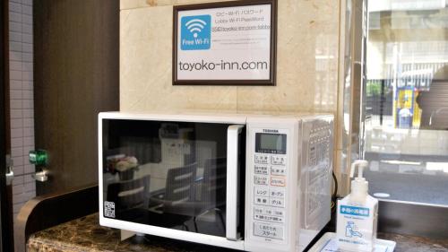 a microwave oven sitting on a counter with a picture on the wall at Toyoko Inn Osaka Nippombashi Bunraku Gekijo Mae in Osaka