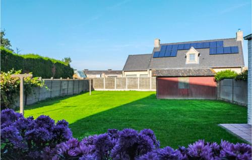 einen Hof mit grünem Gras und lila Blumen in der Unterkunft Cozy Home In Oostvleteren With Wifi in Oostvleteren