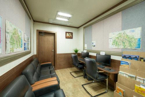 a waiting room with chairs and a desk and a computer at Gyeongju GG Tourist Hotel in Gyeongju