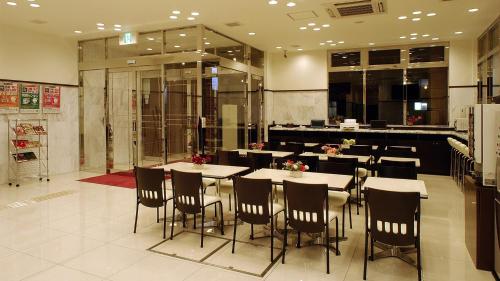 Toyoko Inn Osaka Tsuruhashi Ekimae في أوساكا: مطعم بطاولات وكراسي في مبنى