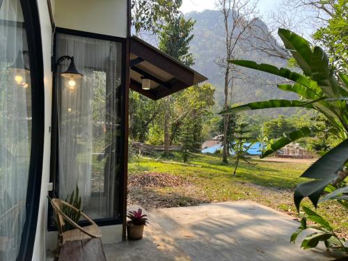 a screened in porch of a house with a window at Ashi Guesthouse Chiangdao in Chiang Dao