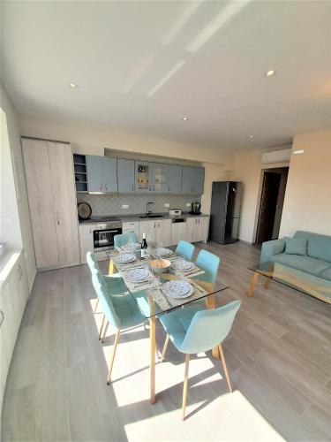 a living room with a table and blue chairs at Mousai Apartment walking distance to the beach in Georgioupolis