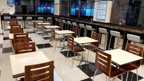 eine Reihe von Tischen und Stühlen in einer Cafeteria in der Unterkunft Toyoko Inn Tokyo Keihin Tohoku sen Oji eki Kita guchi in Tokio