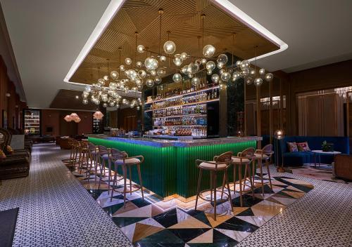 a lobby with a green bar with stools at Holiday Inn Resort Ho Tram Beach by IHG in Ho Tram