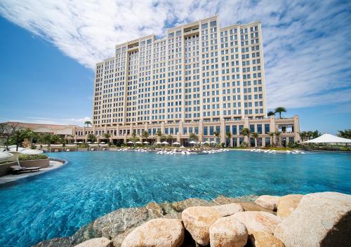 a hotel with a large pool in front of a building at Holiday Inn Resort Ho Tram Beach by IHG in Ho Tram