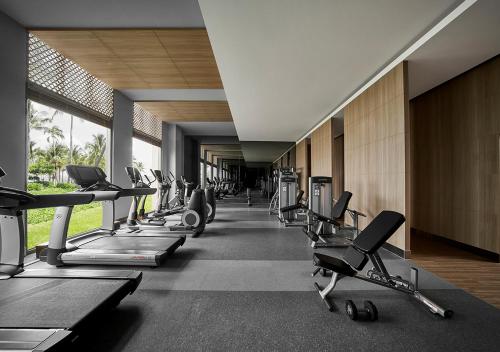 a gym with a row of treadms and cardio machines at Holiday Inn Resort Ho Tram Beach by IHG in Ho Tram