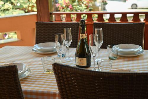 a bottle of wine sitting on a table with glasses at Casa Luisa in Poreč