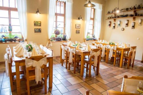 a dining room with wooden tables and chairs at Penzion Restaurace u Helferů in Libuň