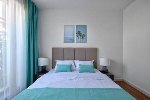 Un dormitorio con una cama grande con dos almohadas azules. en The luxury flat, en Ahtopol