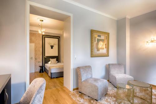 a living room with chairs and a table and a bed at Parkhotel Adler in Hinterzarten