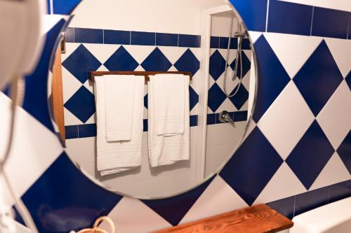 a mirror in a bathroom with blue and white tiles at Casale Ginisara in Castellammare del Golfo