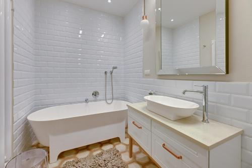 biała łazienka z wanną i umywalką w obiekcie Downtown Apartments Gdynia Seaside Nowe Orłowo w mieście Gdynia