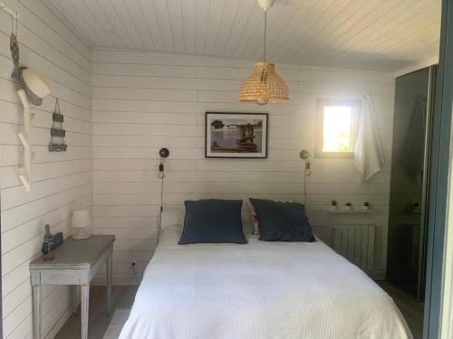 Schlafzimmer mit einem Bett, einem Schreibtisch und einem Kronleuchter in der Unterkunft Ker Mouettes in Arradon