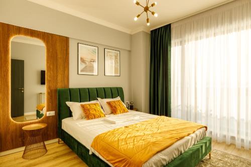 a bedroom with a large bed with a green headboard at Lago Apartment Mamaia Butoaie in Mamaia