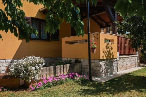 a house with a fence and flowers in the yard at Casa Luisa in Poreč