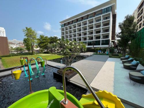 un parque infantil frente a un edificio con un edificio en Fifth Pattaya Jomtien en Jomtien Beach