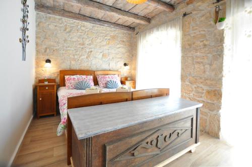 a bedroom with a bed and a stone wall at Villa Gisella in Nedeščina