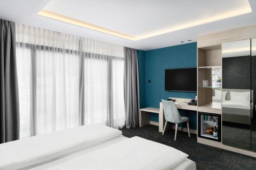 a bedroom with a bed and a desk with a computer at Mercure Tokaj Center in Tokaj