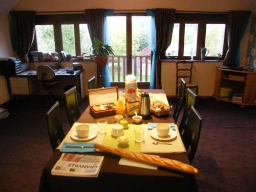 une salle à manger avec une table avec des chaises et un buffet dans l'établissement La Ferme de Montaigu, à Montaigu-les-Bois