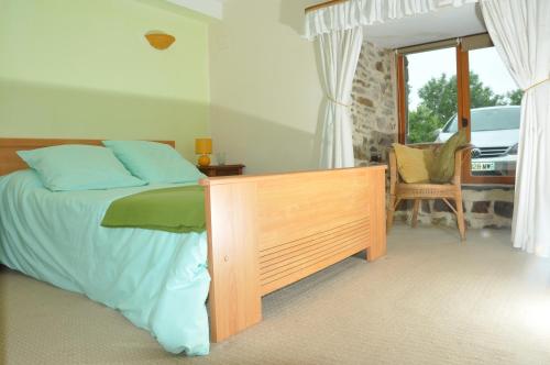 ein Schlafzimmer mit einem Bett, einem Stuhl und einem Fenster in der Unterkunft La Ferme de Montaigu in Montaigu-les-Bois