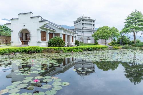 a house and a pond with lilies in front of it at Hualien Toongmao Resort in Jian