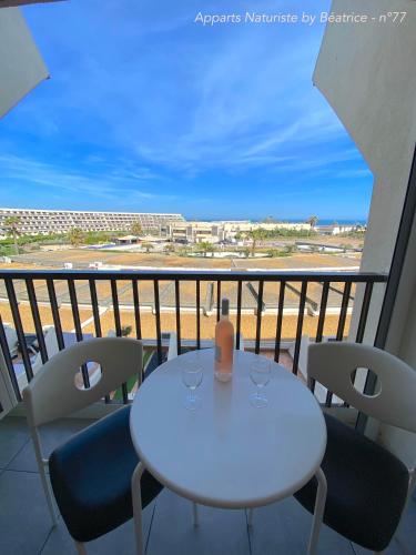 una mesa blanca y sillas en un balcón con vistas en Studios Héliopolis Village Naturiste, en Cap d'Agde
