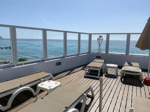 a balcony with tables and chairs and the ocean at Hotel Voramar in Cala Millor