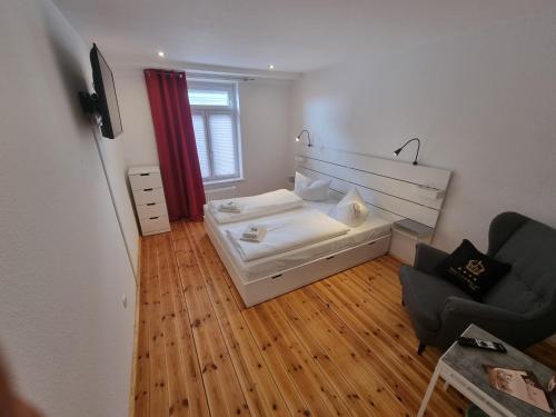 a small room with a bed and a chair at Hotel & Restaurant "Deutscher Kaiser" in Perleberg