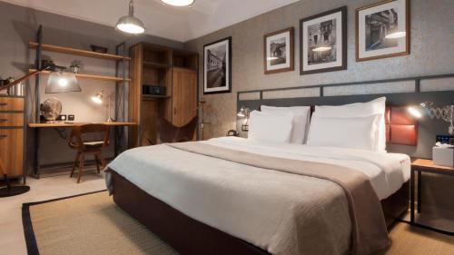 a hotel room with a large bed and a desk at AX The Saint John in Valletta