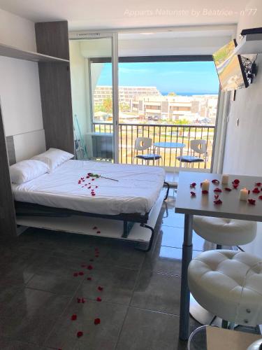 - une chambre avec un lit doté de pétales de rose rouge à l'étage dans l'établissement Studios Héliopolis Village Naturiste, au Cap d'Agde
