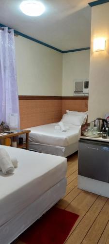 a hotel room with two beds and a tv at Camiguin VIAJEROS House Rental in Compol