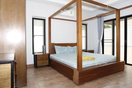 a bedroom with a canopy bed with white sheets at KK Garden 小院 in Hua Hin