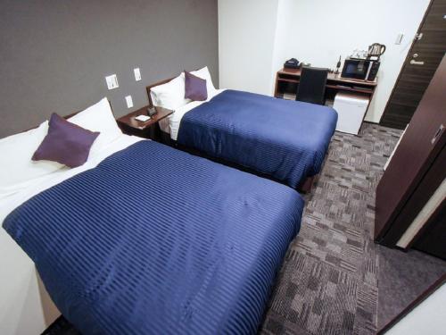 Posteľ alebo postele v izbe v ubytovaní HOTEL LiVEMAX Nagoya Sakae East