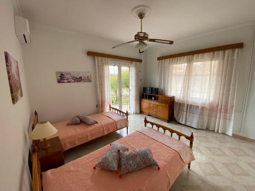 a bedroom with two beds and a ceiling fan at La casa di Costa in Dhorizáta