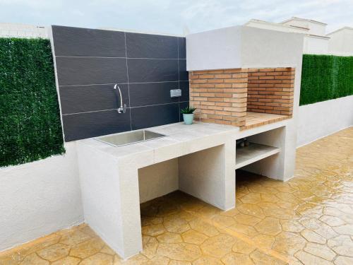 a kitchen with a sink and a brick wall at Sa Tuna - Delta de l'Ebre in Riumar