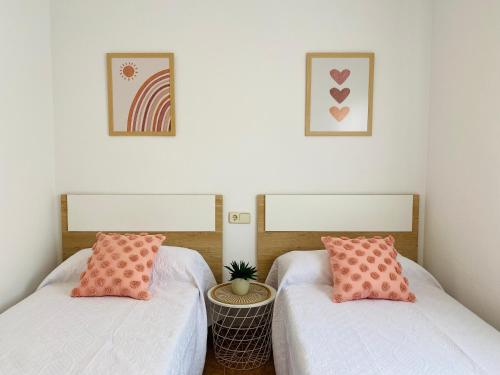 two beds with pink pillows in a room at Sa Tuna - Delta de l'Ebre in Riumar