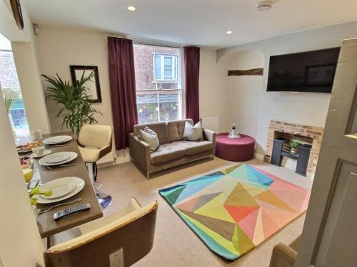 a living room with a table and a colorful rug at The Barbican in York