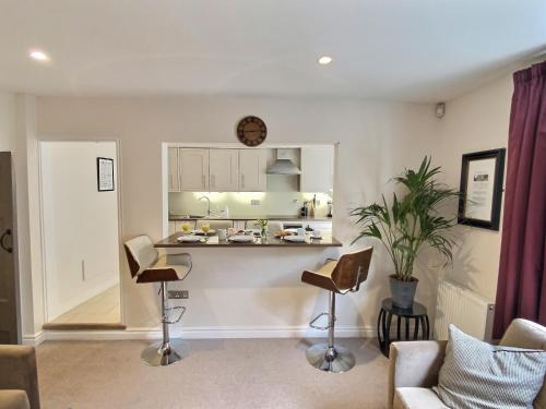 a kitchen and living room with a counter and chairs at The Barbican in York