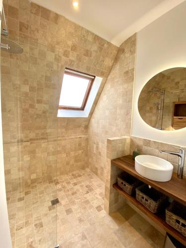 une salle de bain avec un lavabo et un miroir dans l'établissement Les Courtines - Appartement de caractère à la Roque-Gageac - Les Cerisiers, à La Roque-Gageac