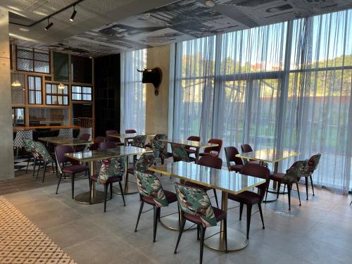 a restaurant with tables and chairs and large windows at Occidental Tanger in Tangier