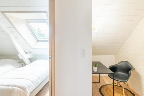 um quarto com uma cama e uma cadeira preta em Bel Even em Plouër-sur-Rance