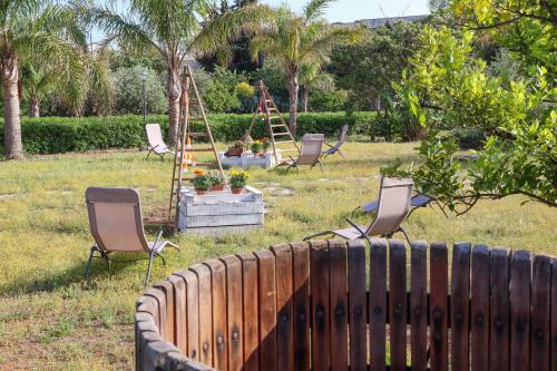 a group of chairs sitting in a yard at B&B Il Giardino di Paola in Alliste