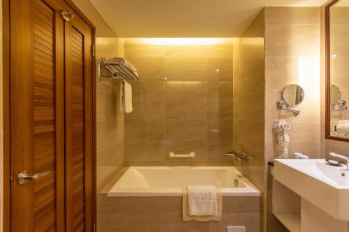 a bathroom with a bath tub and a sink at Hualien Toongmao Resort in Jian